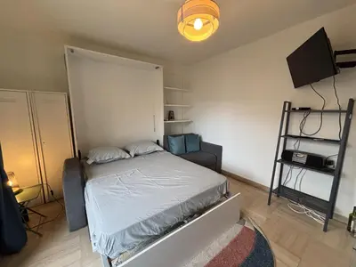 a small bedroom with a bed and a television at Cozy Studio Apt with balcony close to Garibaldi in Nice