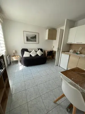 a living room with a black couch and a kitchen at Studio 200m mer et promenade des anglais in Nice