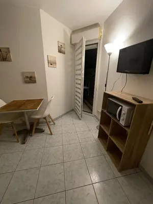 a living room with a table and a television at Studio 200m mer et promenade des anglais in Nice