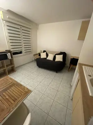 a living room with a black couch in a kitchen at Studio 200m mer et promenade des anglais in Nice
