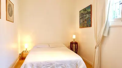 a bedroom with a white bed and a window at Residence les Lauriers in Nice