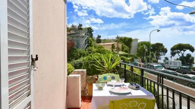 a table on a balcony with a view of a street at Residence les Lauriers in Nice