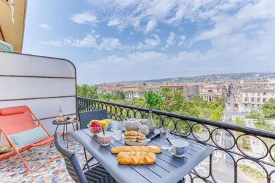 a table with food on top of a balcony at LE PAIROLIERE AP4461 by Riviera Holiday Homes in Nice