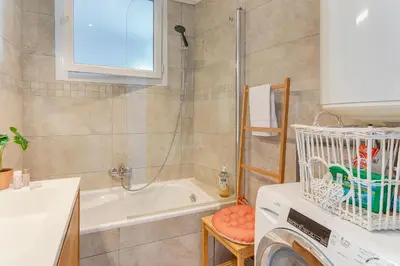 a bathroom with a tub and a washing machine at LE PAIROLIERE AP4461 by Riviera Holiday Homes in Nice