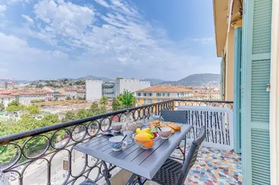 a blue table on a balcony with food on it at LE PAIROLIERE AP4461 by Riviera Holiday Homes in Nice