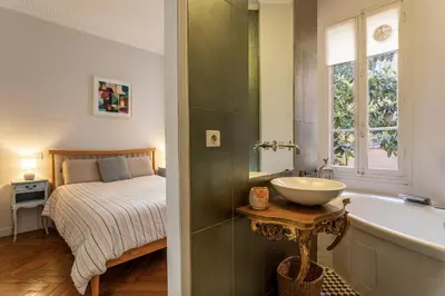 a bathroom with a sink and a bed and a tub at Berlioz Blue AP4458 by Riviera Holiday Homes in Nice