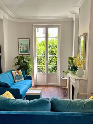 a living room with a blue couch and a fireplace at Berlioz Blue AP4458 by Riviera Holiday Homes in Nice