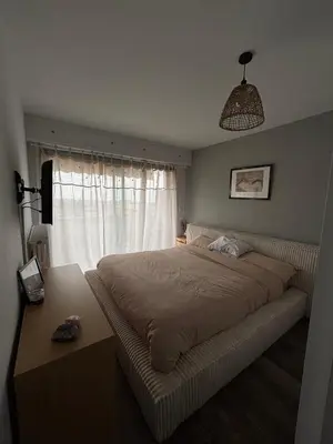 a bedroom with a large bed and a window at Appartement de Tim in Cagnes-sur-Mer