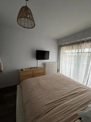 a bedroom with a large bed and a television at Appartement de Tim in Cagnes-sur-Mer