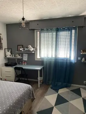 a bedroom with a bed and a desk and a window at Appartement de Tim in Cagnes-sur-Mer