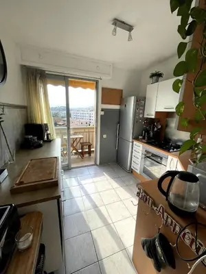 a small kitchen with a view of a balcony at Appartement de Tim in Cagnes-sur-Mer