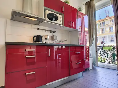 a kitchen with red cabinets and a large window at Nestor&Jeeves - DOLCE VITA STUDIO - Balcon - Central in Nice