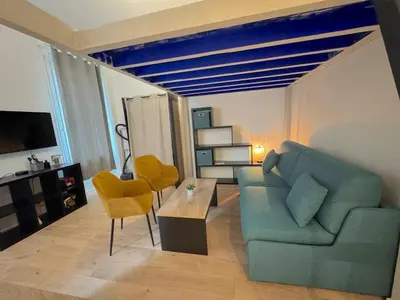 a large bed in a room with a blue couch at ⁂Appartement élégant plage à 100m prom des anglais in Nice
