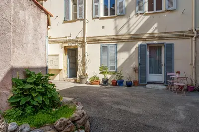 a white building with blue shuttered windows and plants at Nice Renting - CLEMENCEAU - Riviera Cocoon Calm Elegance Design in Nice