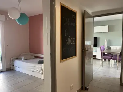 a bedroom with a bed and a dining room at 3 pièces central au pied de la promenade du paillon in Nice
