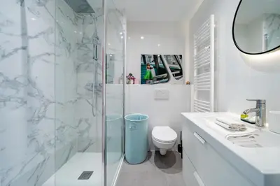 a white bathroom with a shower and a toilet at Studio Vue mer Parking Clim in Nice