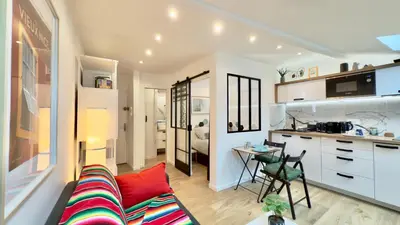 a living room with a couch and a table and a kitchen at Ze Perfect Place - Magnifique Studio Vieux Nice in Nice