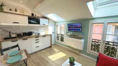 a kitchen with white cabinets and a flat screen tv at Ze Perfect Place - Magnifique Studio Vieux Nice in Nice
