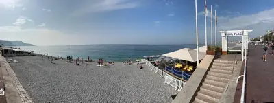 a group of people on a beach near the ocean at Carre d Or Face a la Mer in Nice