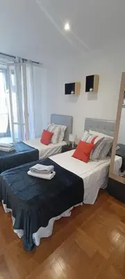 a room with two beds with red pillows at Appartement vue mer et panoramique, 2 chambres, 3 lits in Nice