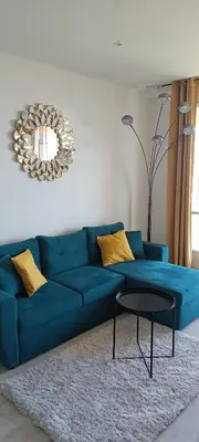 a blue couch in a living room with a table at Appartement vue mer et panoramique, 2 chambres, 3 lits in Nice