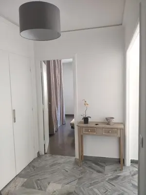 a white room with a table and a mirror at 3 pièces 67m2 centre ville très lumineux et calme in Nice