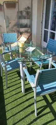 a glass table and chairs on a lawn at Nice, vue mer et panoramique in Nice