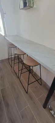 a table and two stools under a table with a counter at Nice, vue mer et panoramique in Nice