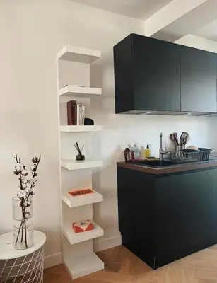 a kitchen with a black counter and white shelves at Nice vieille ville appartement design, proche de tout in Nice