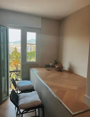 a kitchen with a counter with two chairs and a window at Nice vieille ville appartement design, proche de tout in Nice