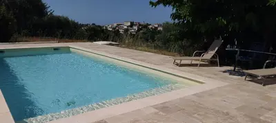 a swimming pool with a chair and a table at Beautiful Villa with large pool and garden 20 mn from Nice in Colomars
