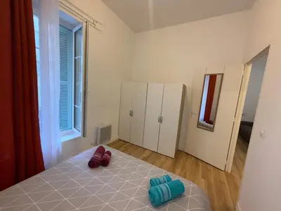 a bedroom with a bed and a large window at Villa Amira Angely Vauban in Nice