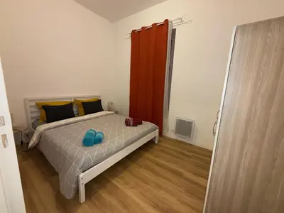 a bedroom with a bed and a red curtain at Villa Amira Angely Vauban in Nice