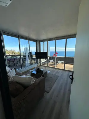 a living room with a couch and a view of the ocean at Casa Monaco - Costa plana résidence in Cap d'Ail