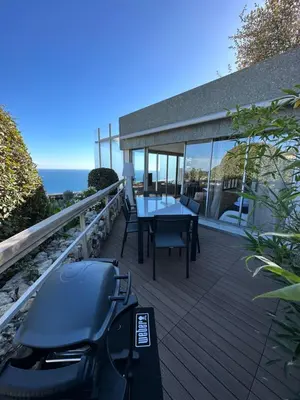 a deck with a table and chairs on it at Casa Monaco - Costa plana résidence in Cap d'Ail
