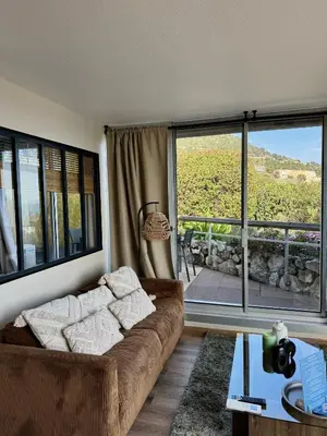 a living room with a couch and a large window at Casa Monaco - Costa plana résidence in Cap d'Ail