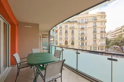 a balcony with a green table and chairs and a building at Charming stay in Nice in Nice