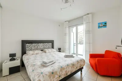 a bedroom with a bed and a red chair at Charming stay in Nice in Nice