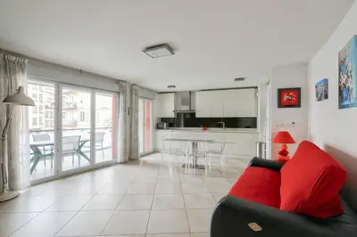 a living room with a red couch and a kitchen at Charming stay in Nice in Nice