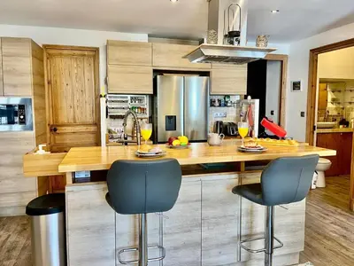 a kitchen with a wooden counter and two blue bar stools at Le Splendide in Nice