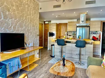 a kitchen with a television and a table with chairs at Le Splendide in Nice