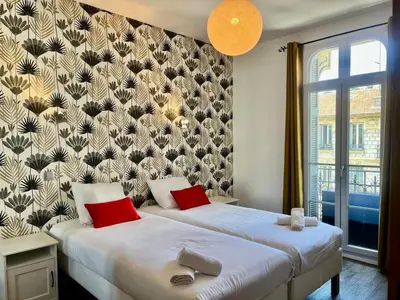 a bedroom with a large white bed with red pillows at Le Splendide in Nice