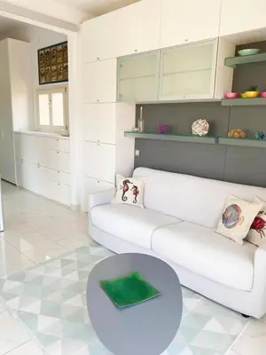 a living room with a white couch and a table at Appartamento vista mare in Saint-Jean-Cap-Ferrat