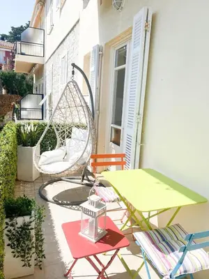 a patio with a swing and chairs and a table at Appartamento vista mare in Saint-Jean-Cap-Ferrat