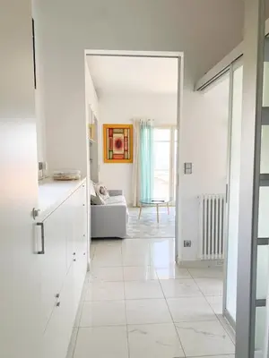a living room with white walls and a large mirror at Appartamento vista mare in Saint-Jean-Cap-Ferrat