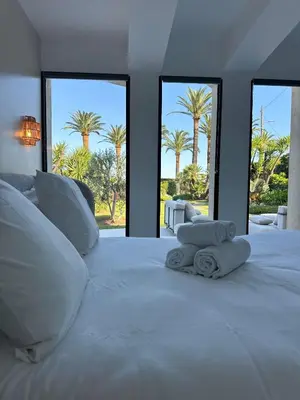 a bedroom with a large white bed with palm trees at Luxury Villa Pool & Sea View in Nice