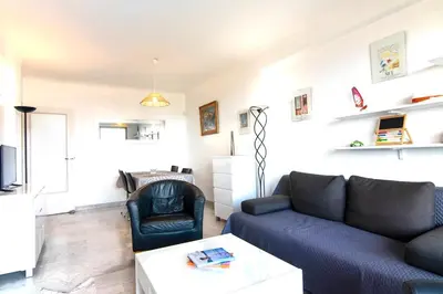 a living room with a couch and a table at 3 rooms panoramic sea view in Beaulieu-sur-Mer