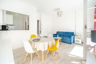 a dining room and living room with a table and chairs at Studio proche mer avec jardin in Nice
