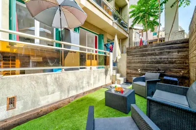 a patio with chairs and an umbrella on a building at Studio proche mer avec jardin in Nice