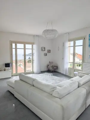 a large white living room with a large couch at Suggestivo appartamento in Saint-Jean-Cap-Ferrat
